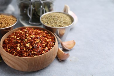 Photo of Different aromatic spices on grey table, closeup. Space for text
