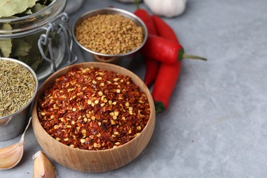 Photo of Different aromatic spices on grey table, closeup. Space for text