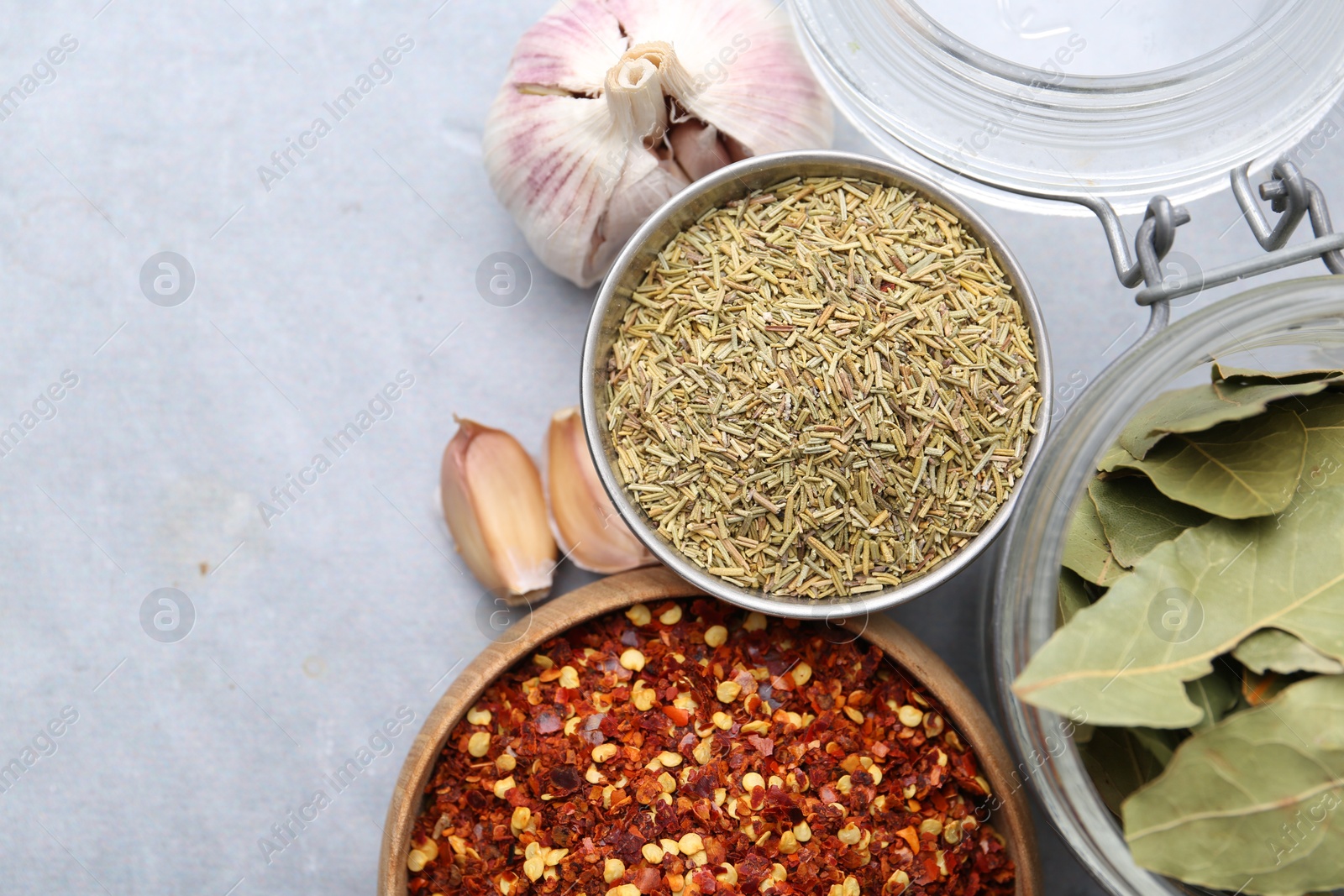 Different aromatic spices on grey table, flat lay. Space for text Photo of Different aromatic spices on grey table, flat lay. Space for text