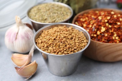 Photo of Different aromatic spices on grey table, selective focus