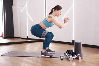 Photo of Woman exercising with elastic band in fitness studio