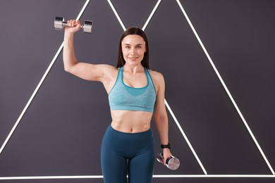 Photo of Woman exercising with dumbbells in fitness studio