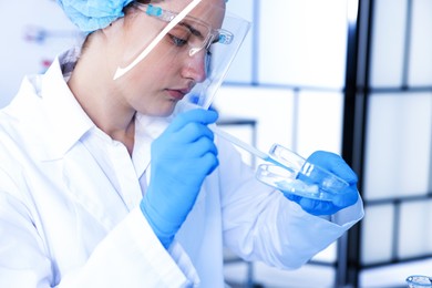 Photo of Scientist working with sample in Petri dish in laboratory