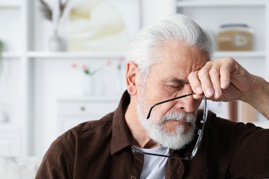 Photo of Senior man suffering from eyestrain at home