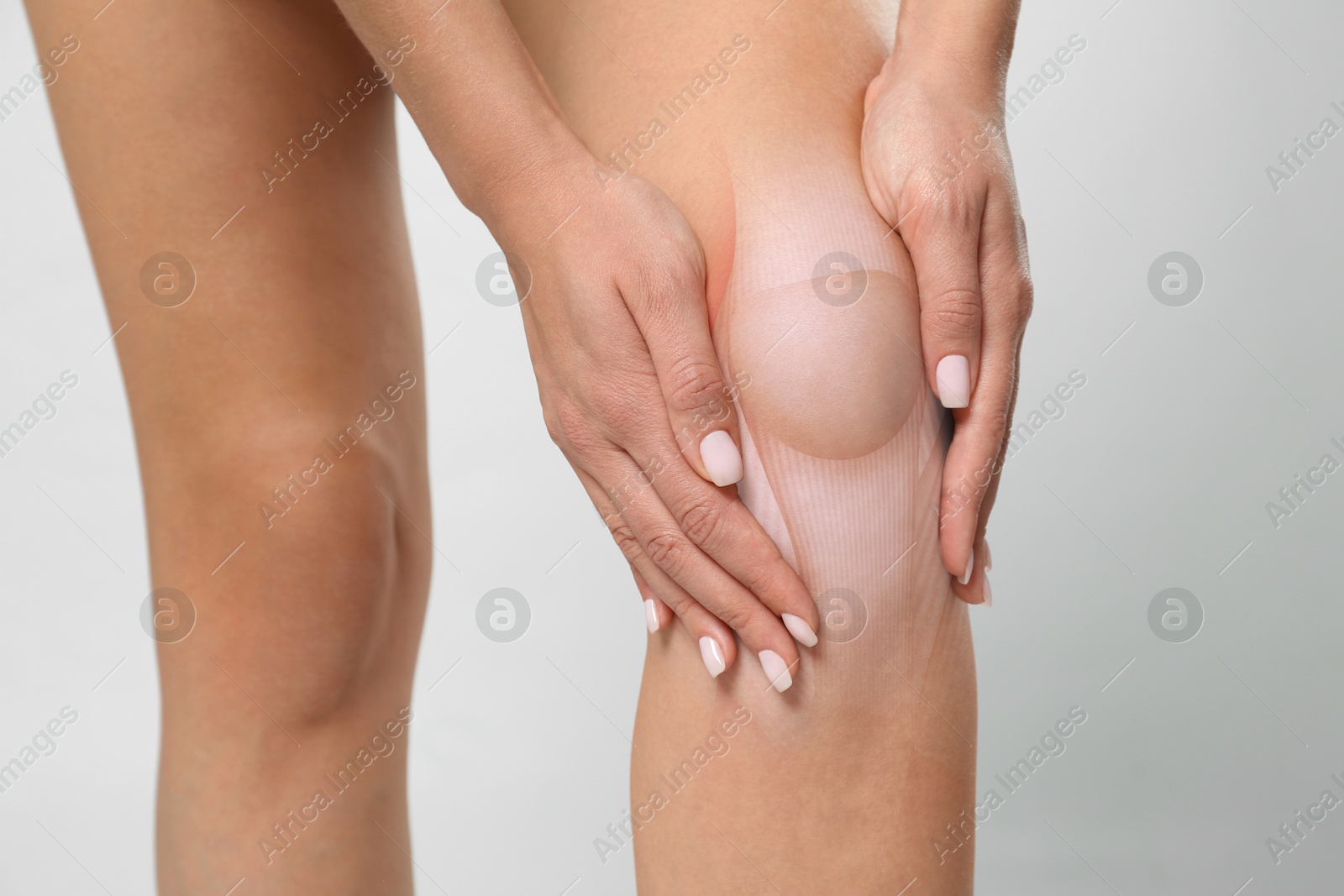 Anatomy of knee. Woman with illustration on her leg against grey background, closeup Image of Anatomy of knee. Woman with illustration on her leg against grey background, closeup