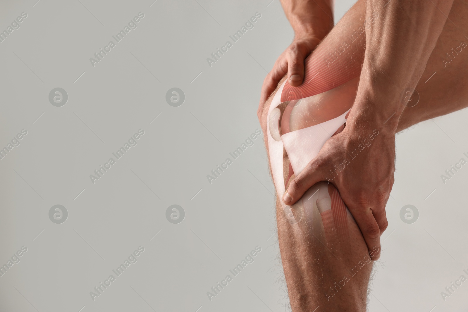 Anatomy of knee. Man with illustration on his leg against grey background, closeup. Space for text Image of Anatomy of knee. Man with illustration on his leg against grey background, closeup. Space for text