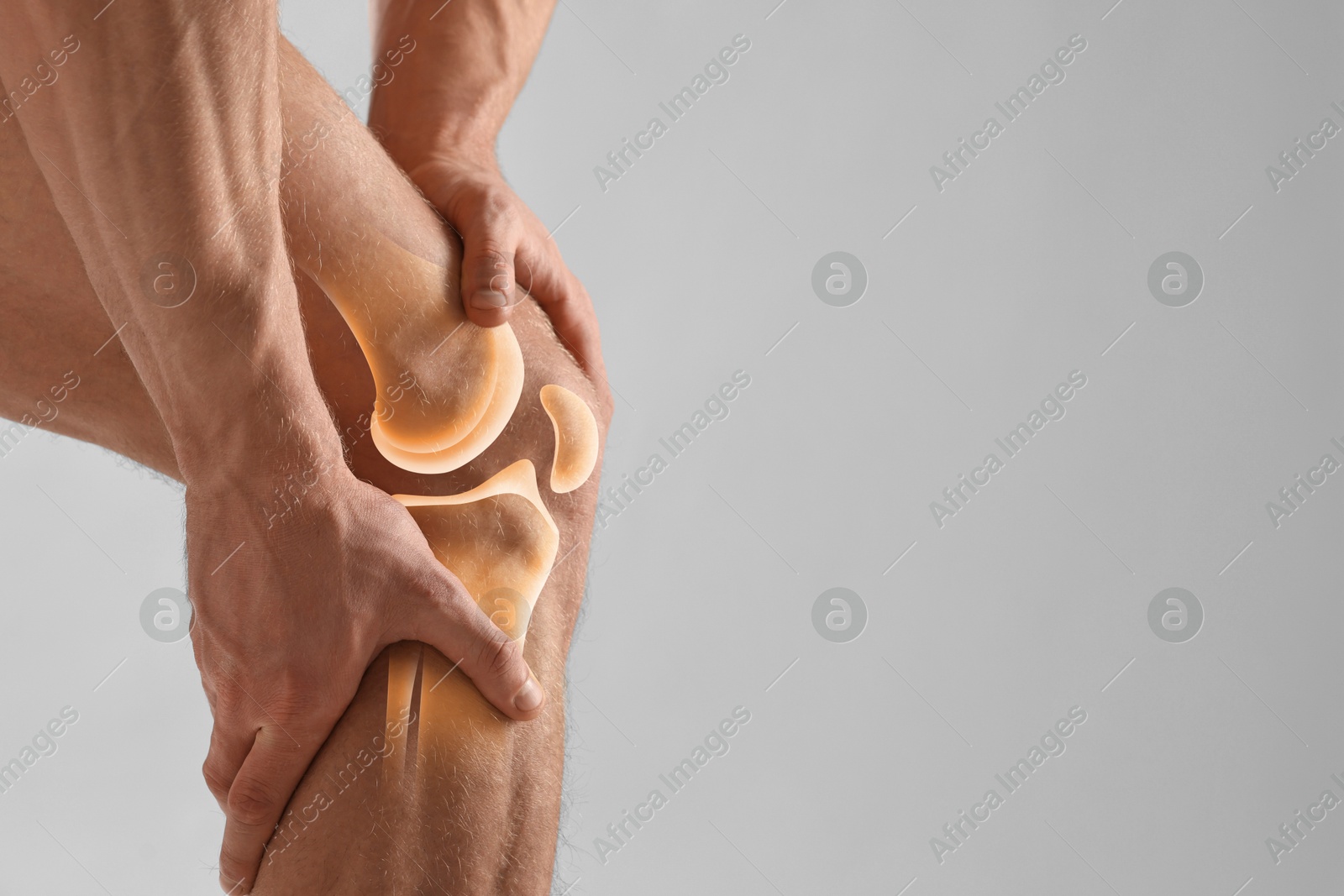 Anatomy of knee. Man with illustration on his leg against grey background, closeup. Space for text Image of Anatomy of knee. Man with illustration on his leg against grey background, closeup. Space for text