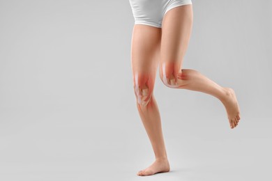 Image of Anatomy of knee. Woman running against grey background, closeup. Illustration on her leg
