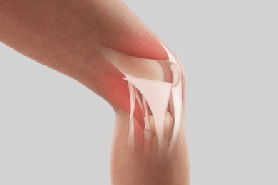 Image of Anatomy of knee. Woman with illustration on her leg against grey background, closeup