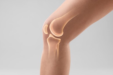 Image of Anatomy of knee. Woman with illustration on her leg against grey background, closeup