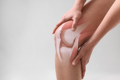 Image of Anatomy of knee. Woman with illustration on her leg against grey background, closeup. Space for text
