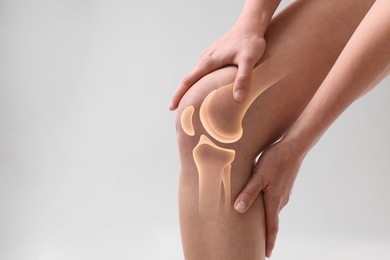 Image of Anatomy of knee. Woman with illustration on her leg against grey background, closeup. Space for text