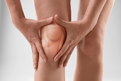 Image of Anatomy of knee. Woman with illustration on her leg against grey background, closeup