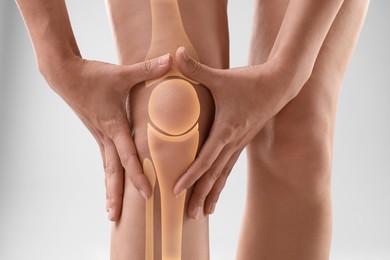 Image of Anatomy of knee. Woman with illustration on her leg against grey background, closeup