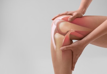 Image of Anatomy of knee. Woman with illustration on her leg against grey background, closeup. Space for text