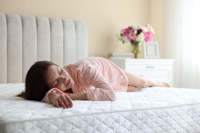 Photo of Woman sleeping on bed with orthopedic mattress at home