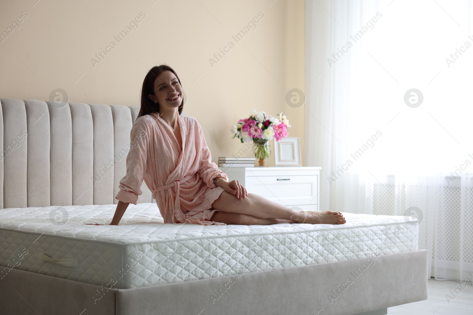 Woman on bed with orthopedic mattress at home Photo of Woman on bed with orthopedic mattress at home