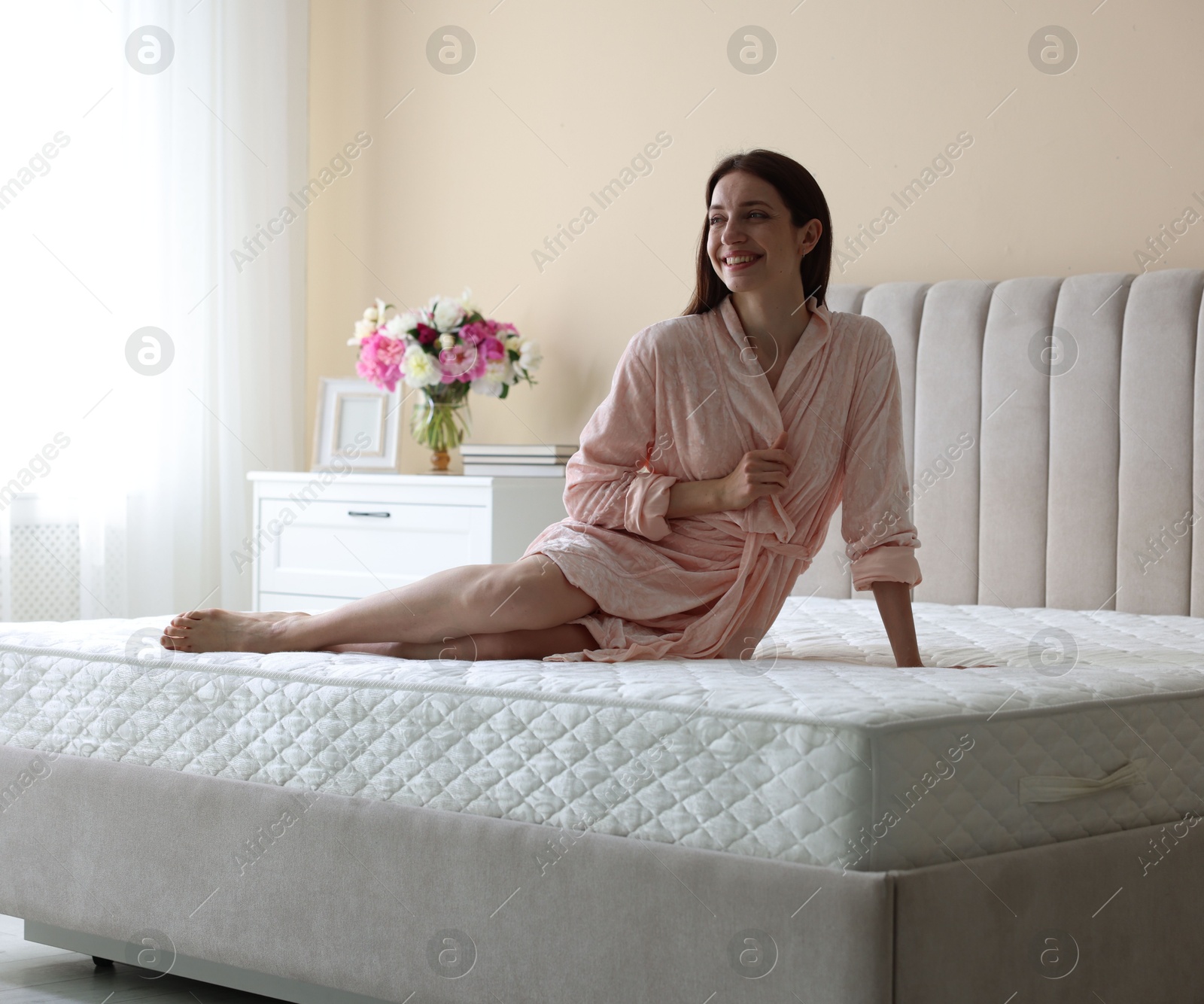 Woman on bed with orthopedic mattress at home Photo of Woman on bed with orthopedic mattress at home