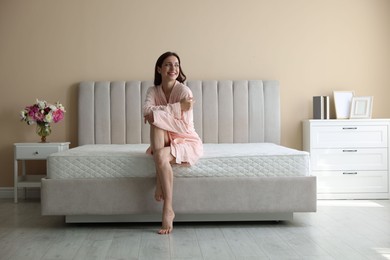 Photo of Woman on bed with orthopedic mattress at home