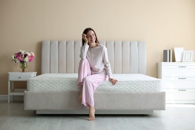 Photo of Woman on bed with orthopedic mattress at home