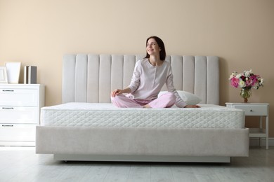 Photo of Woman on bed with orthopedic mattress at home