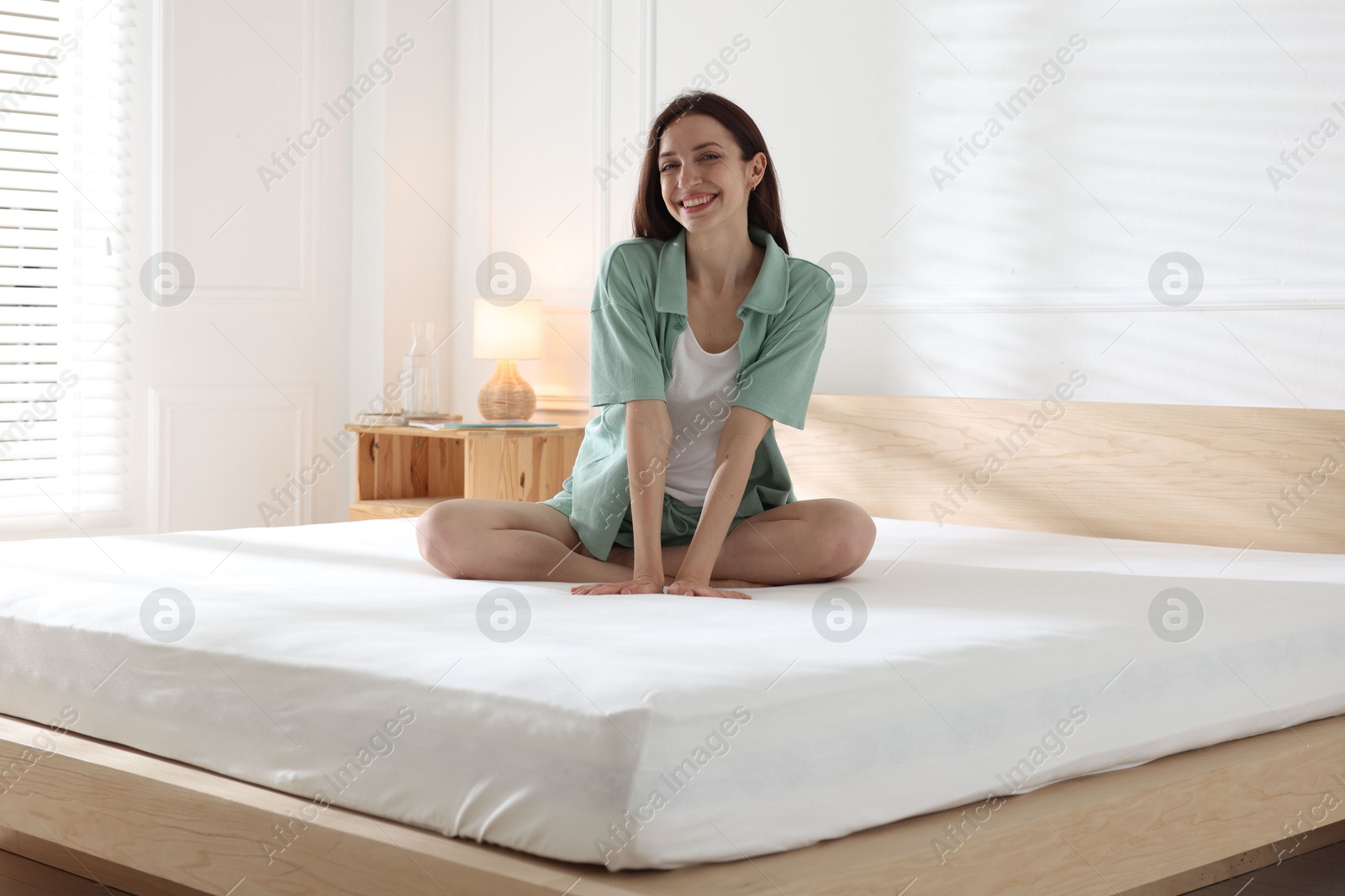 Woman on bed with soft mattress at home Photo of Woman on bed with soft mattress at home