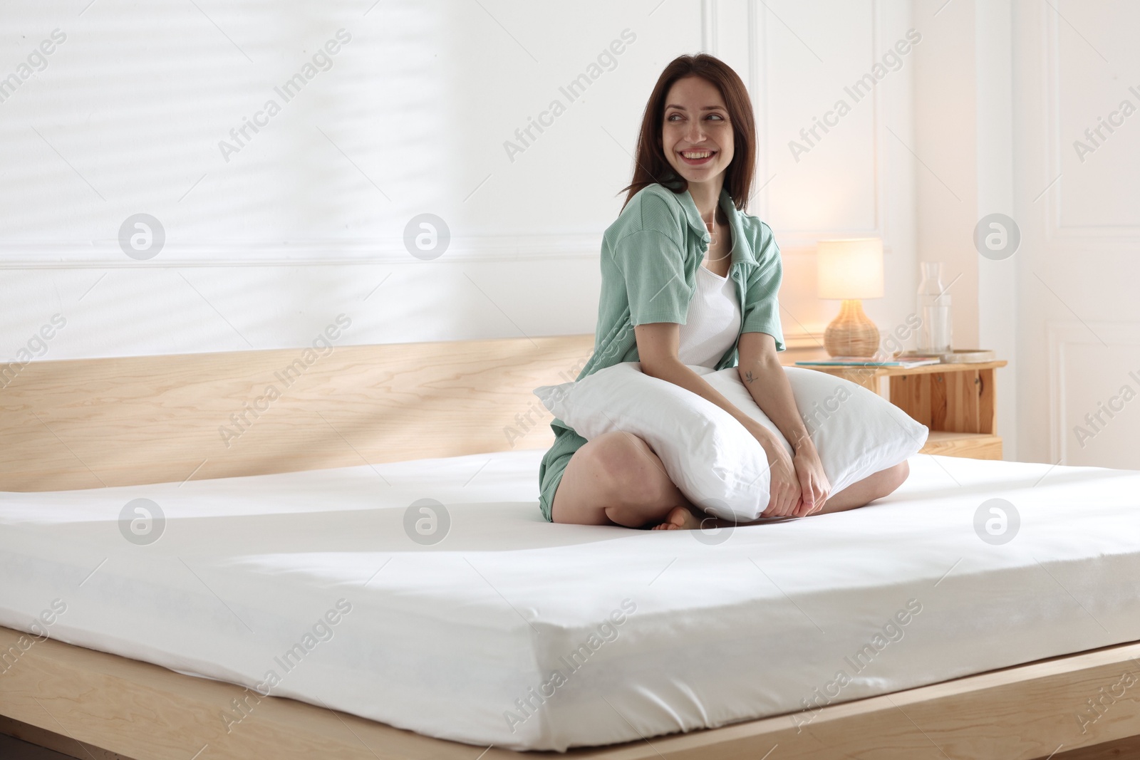 Woman on bed with soft mattress at home Photo of Woman on bed with soft mattress at home