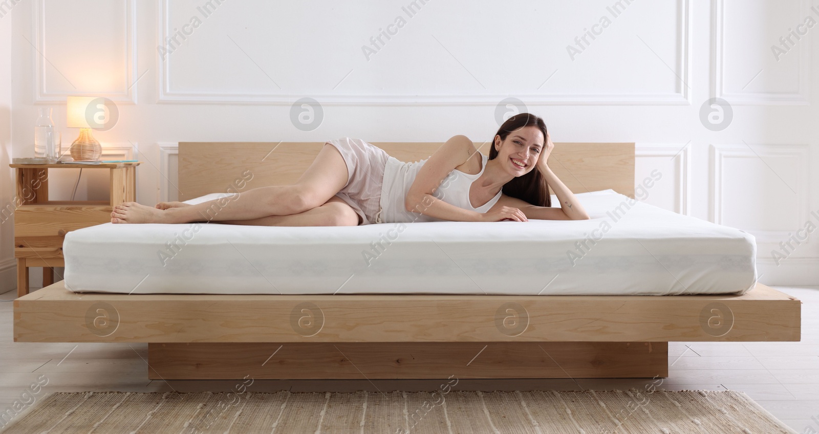Woman lying on bed with orthopedic mattress at home Photo of Woman lying on bed with orthopedic mattress at home