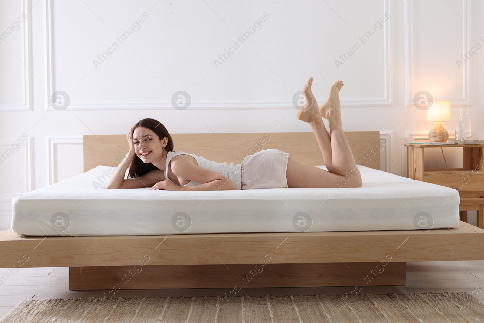 Woman lying on bed with orthopedic mattress at home Photo of Woman lying on bed with orthopedic mattress at home