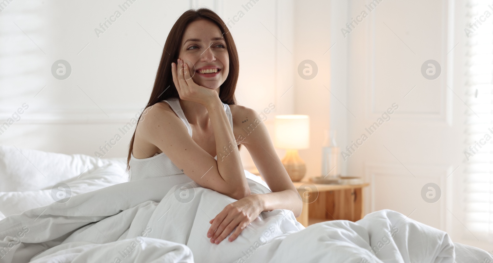 Woman on bed with soft mattress at home Photo of Woman on bed with soft mattress at home