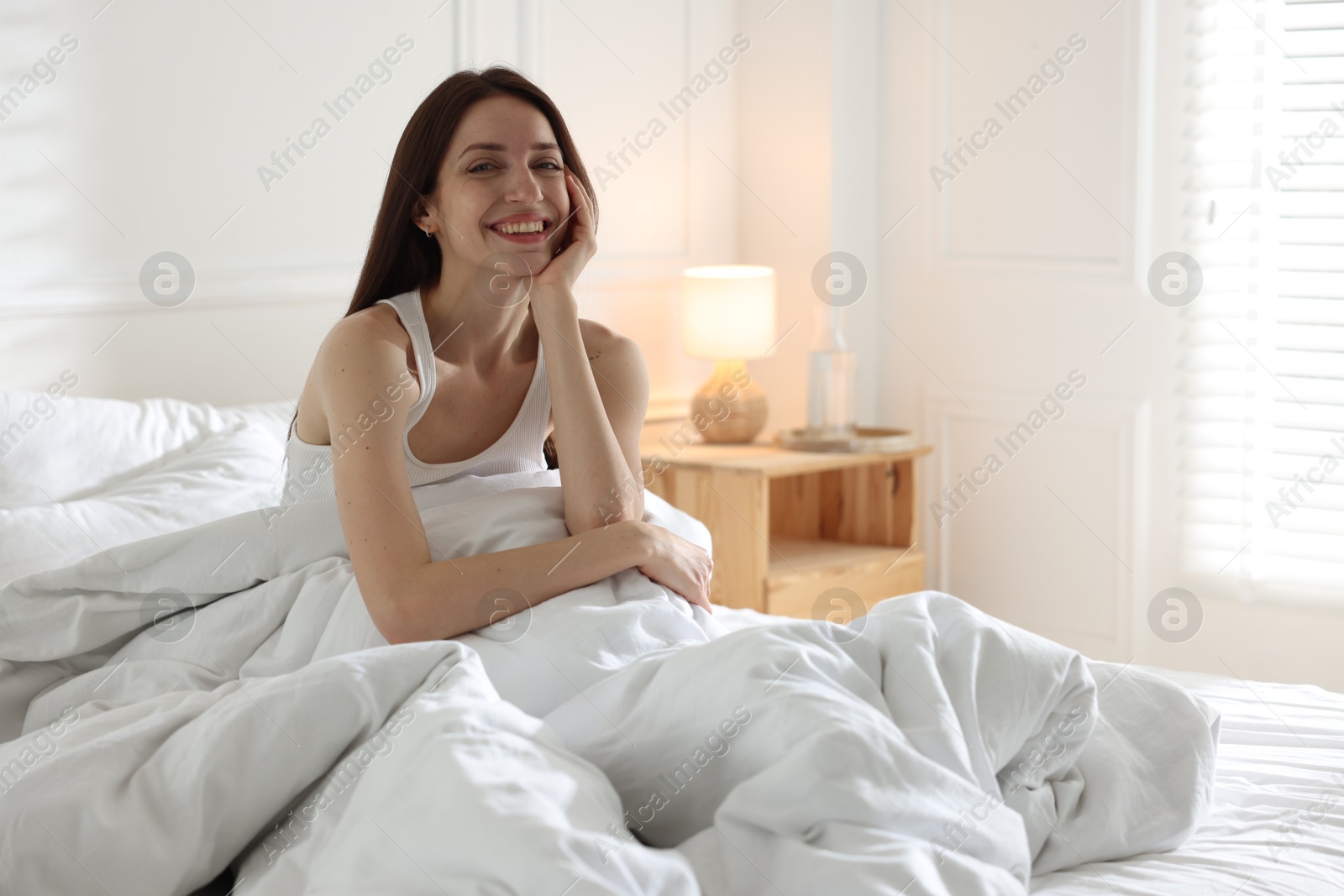 Woman on bed with soft mattress at home Photo of Woman on bed with soft mattress at home