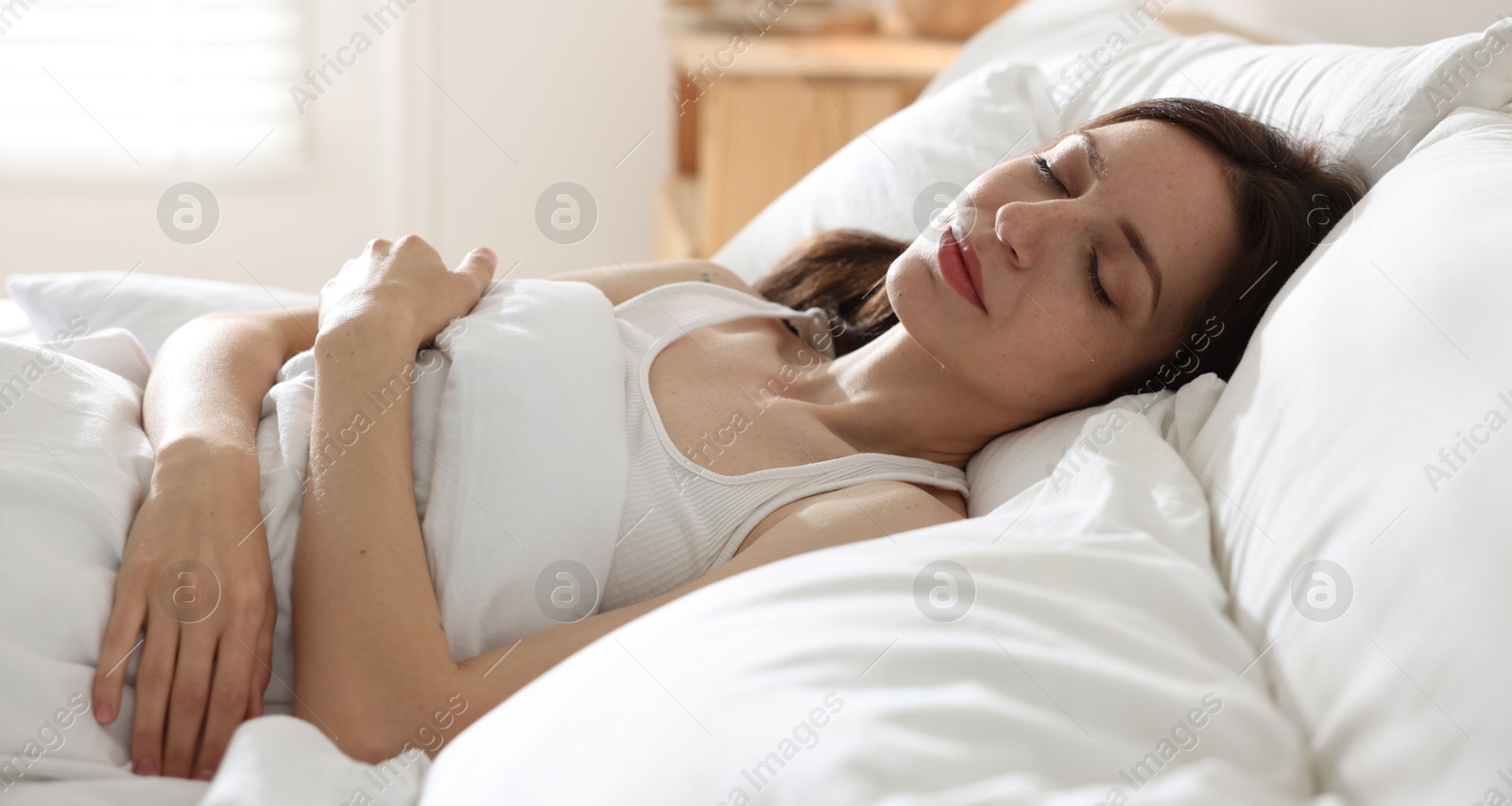 Woman sleeping on bed with soft mattress at home Photo of Woman sleeping on bed with soft mattress at home
