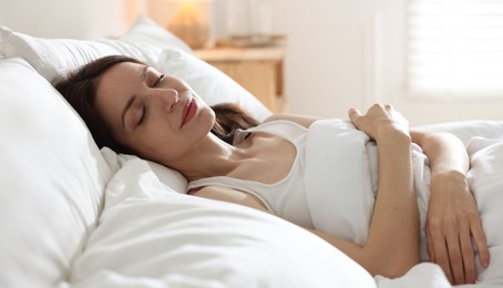 Photo of Woman sleeping on bed with soft mattress at home
