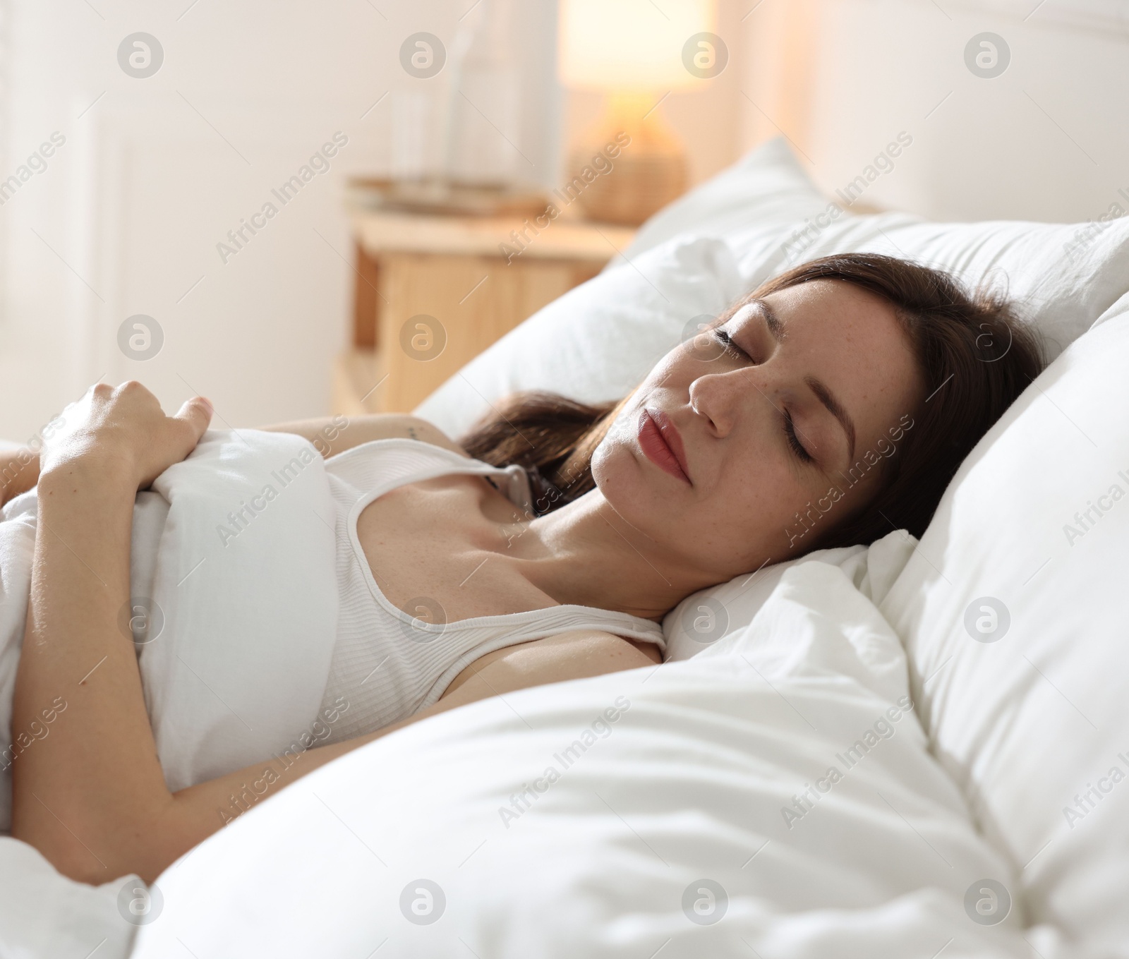 Woman sleeping on bed with soft mattress at home Photo of Woman sleeping on bed with soft mattress at home