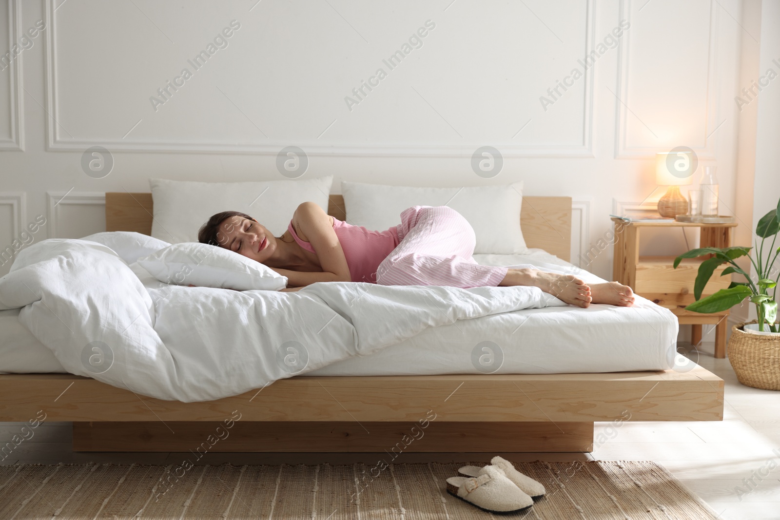 Woman sleeping on bed with soft mattress at home Photo of Woman sleeping on bed with soft mattress at home