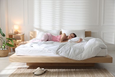 Photo of Woman sleeping on bed with soft mattress at home