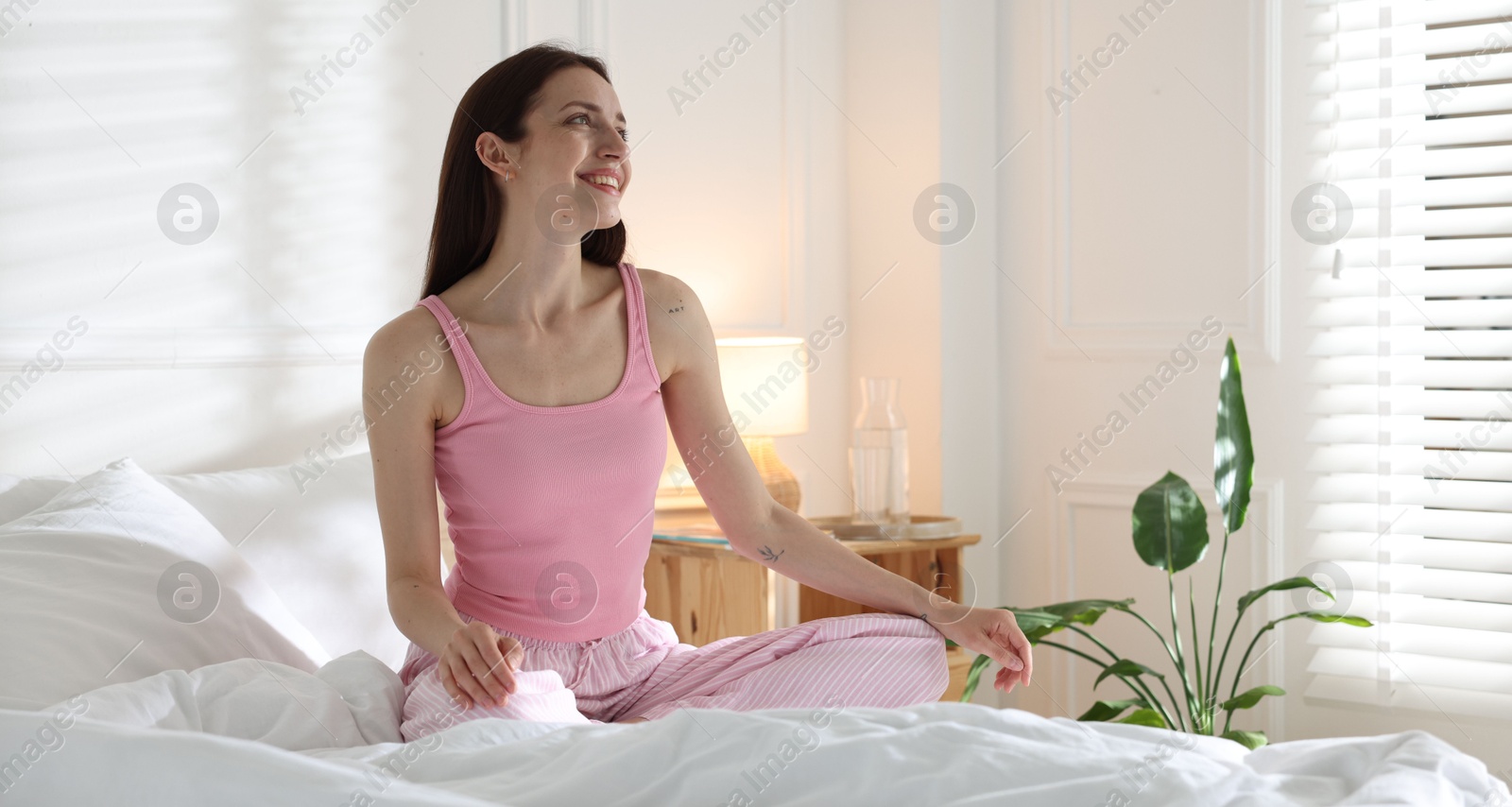Woman on bed with soft mattress at home. Space for text Photo of Woman on bed with soft mattress at home. Space for text