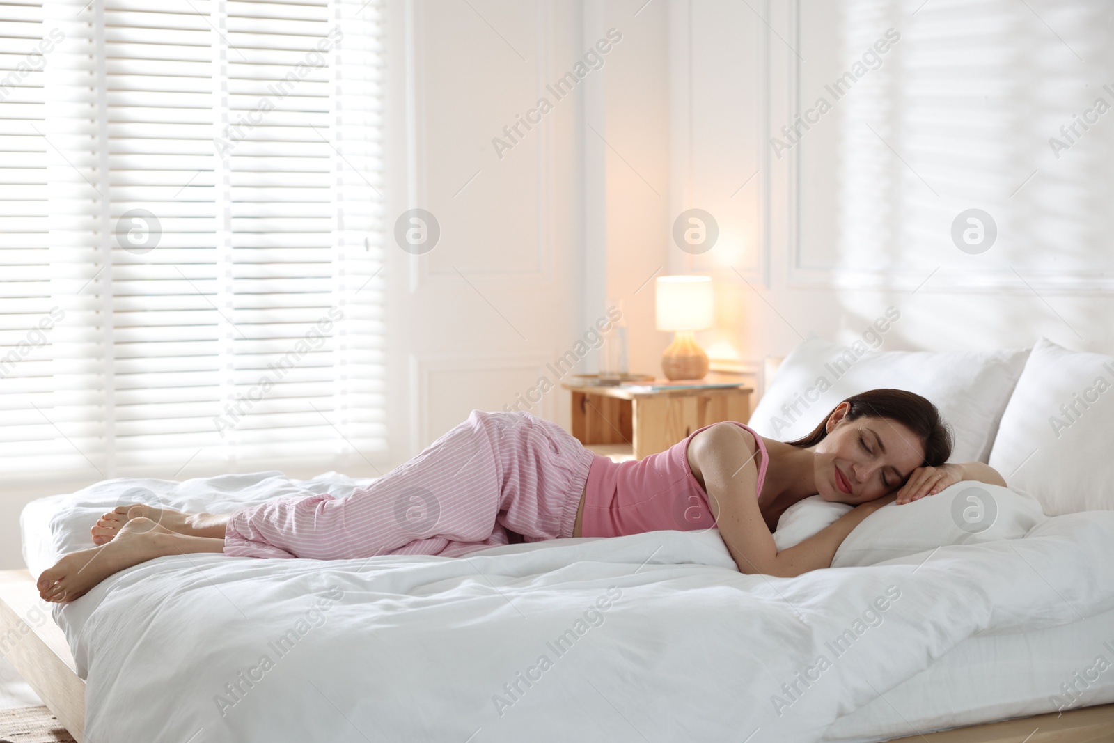 Woman sleeping on bed with soft mattress at home. Space for text Photo of Woman sleeping on bed with soft mattress at home. Space for text