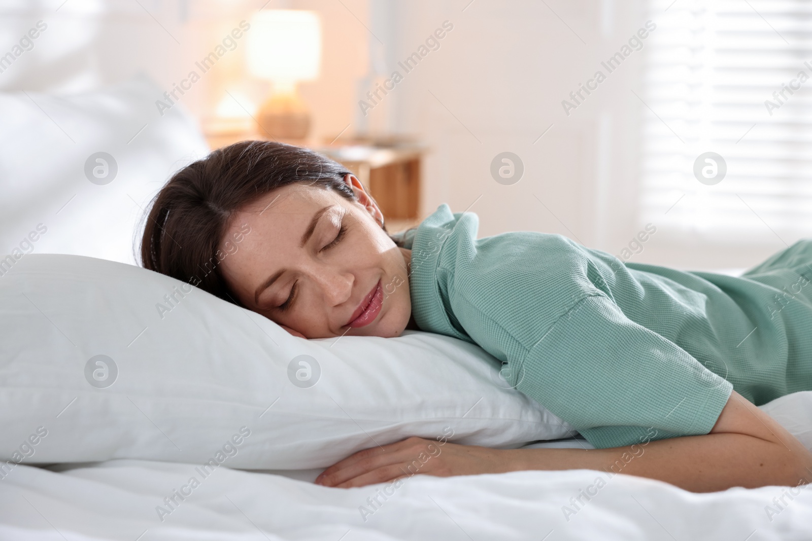 Woman sleeping on bed with soft mattress at home Photo of Woman sleeping on bed with soft mattress at home