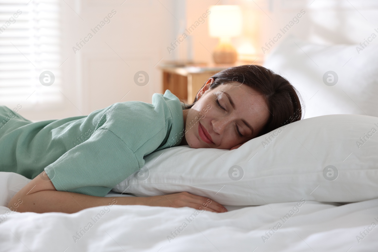 Woman sleeping on bed with soft mattress at home Photo of Woman sleeping on bed with soft mattress at home