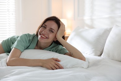 Photo of Woman lying on bed with soft mattress at home