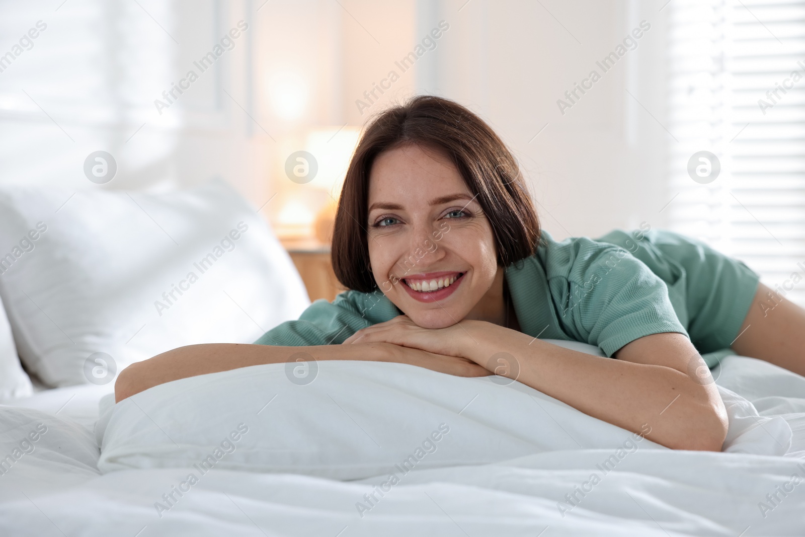Woman lying on bed with soft mattress at home Photo of Woman lying on bed with soft mattress at home