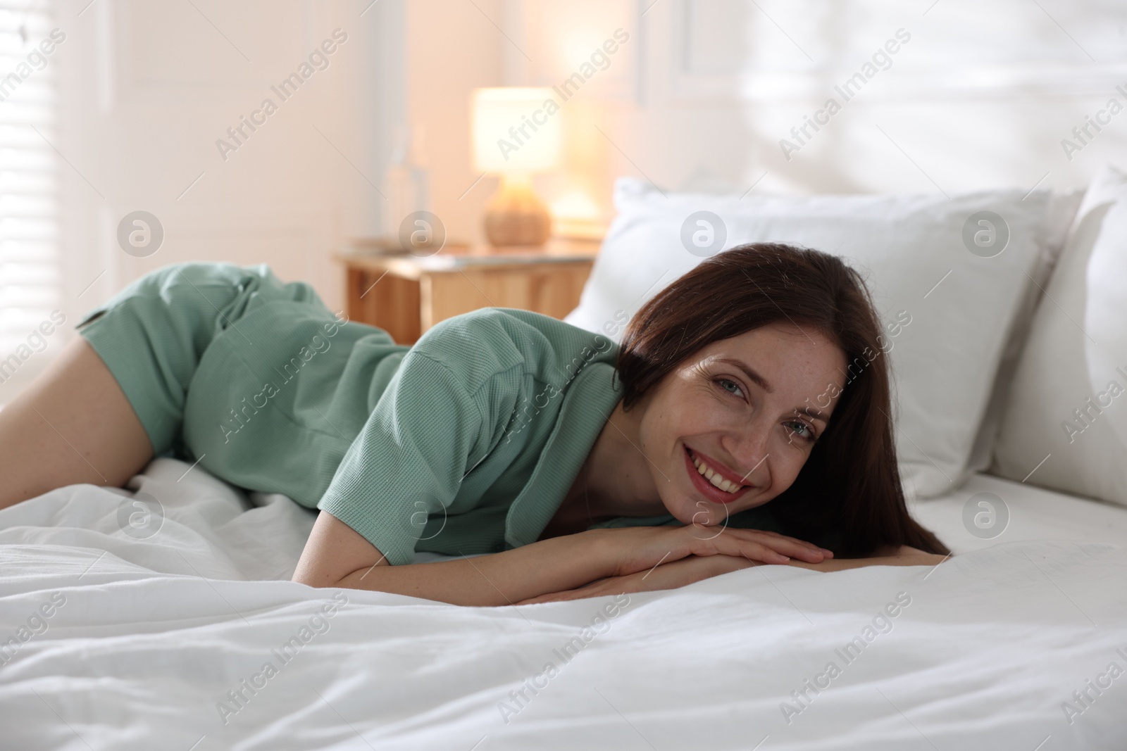 Woman lying on bed with soft mattress at home Photo of Woman lying on bed with soft mattress at home
