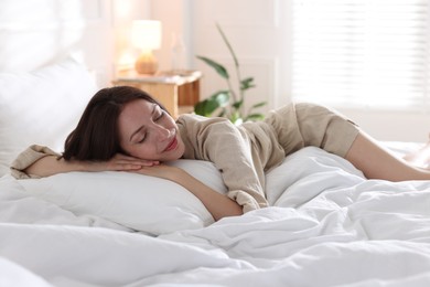 Photo of Woman sleeping on bed with soft mattress at home