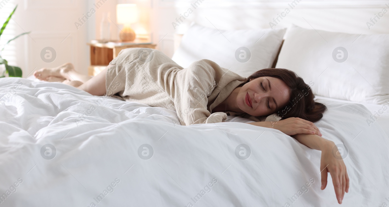 Woman sleeping on bed with soft mattress at home Photo of Woman sleeping on bed with soft mattress at home
