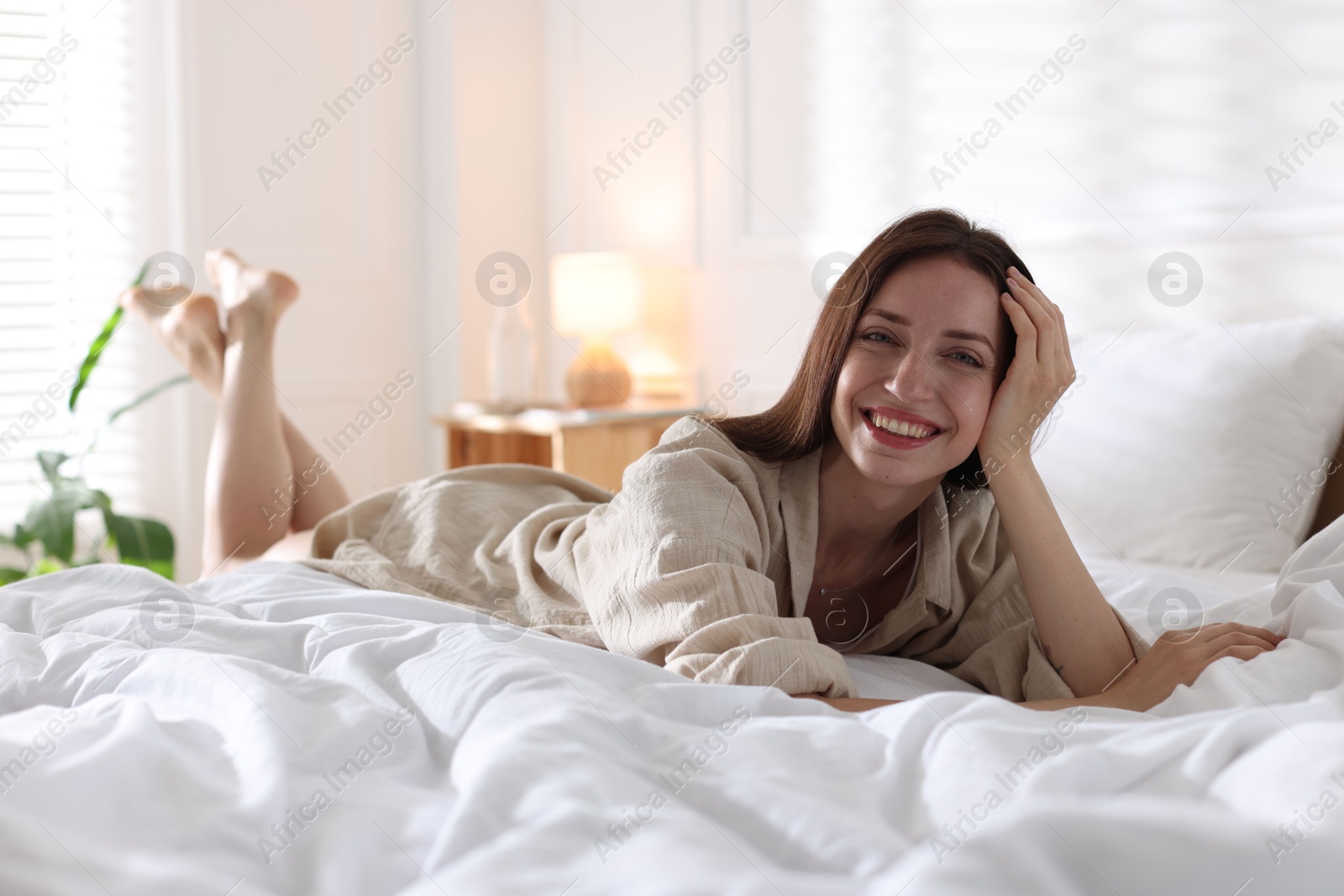 Woman lying on bed with soft mattress at home Photo of Woman lying on bed with soft mattress at home
