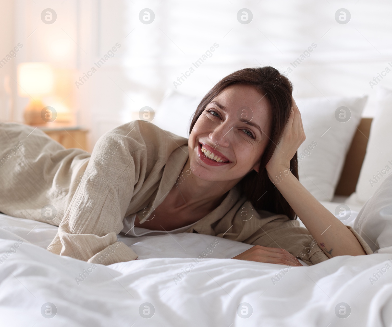 Woman lying on bed with soft mattress at home Photo of Woman lying on bed with soft mattress at home