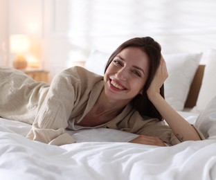 Photo of Woman lying on bed with soft mattress at home