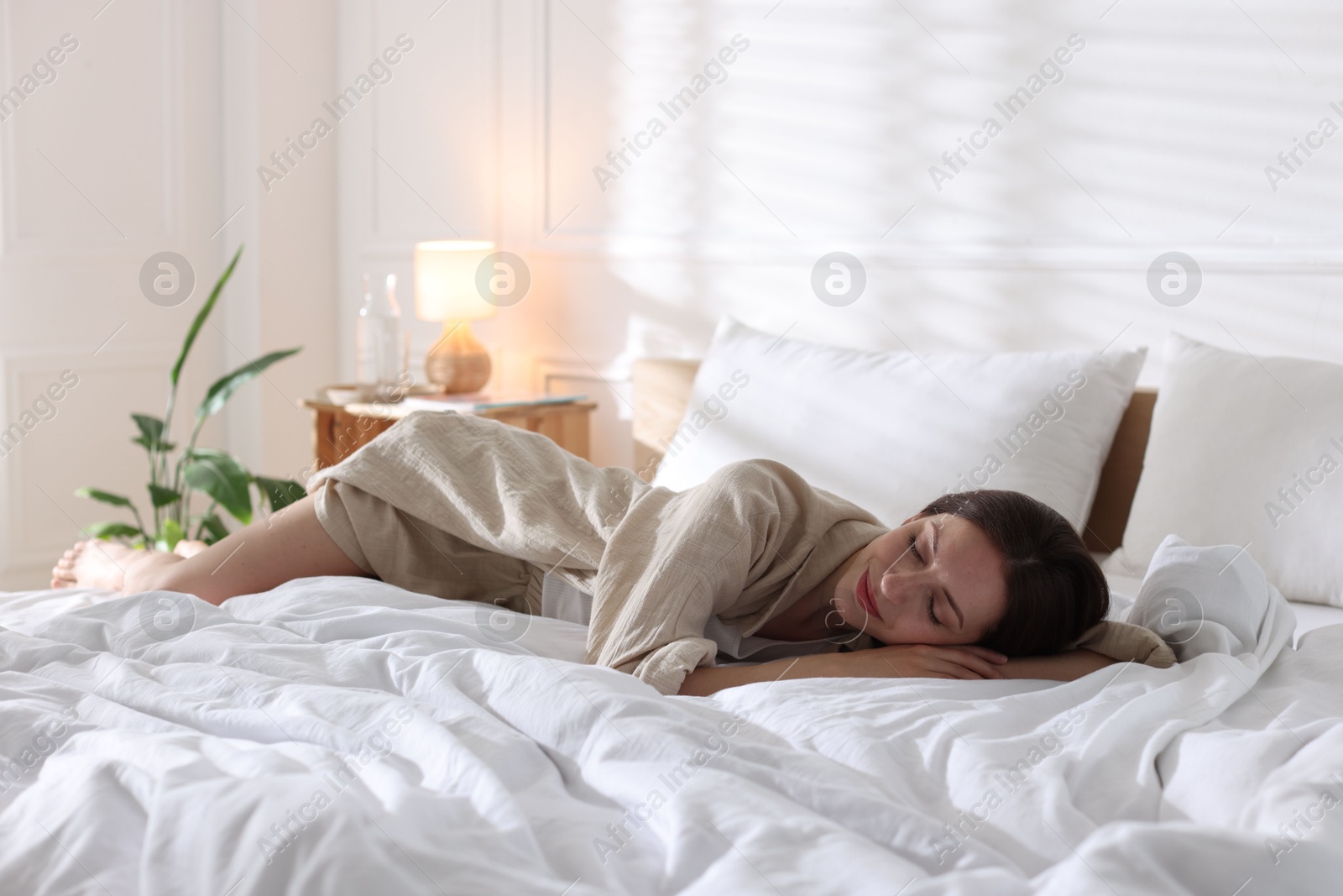 Woman sleeping on bed with soft mattress at home. Space for text Photo of Woman sleeping on bed with soft mattress at home. Space for text