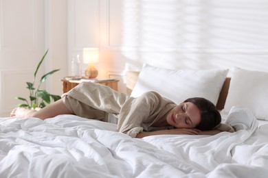 Photo of Woman sleeping on bed with soft mattress at home. Space for text